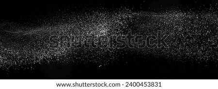 Freezing falling particles or stardust in air on black background for overlay blending mode. Stopping the movement of white powder on a dark background, selective focus, wide banner Royalty-Free Stock Photo #2400453831