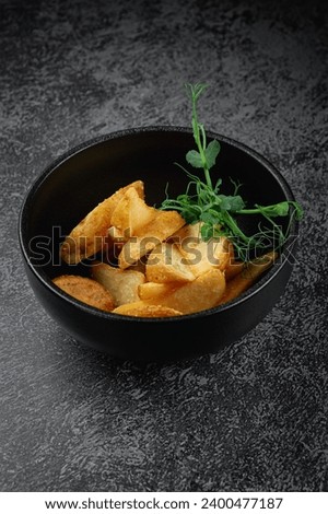 Potato wedges roasted in the oven in a dark plate