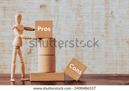 There is wood cube with the word Pros or Cons. It is as an eye-catching image. Royalty-Free Stock Photo #2400486537