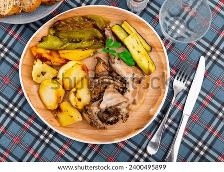 Dietary roasted rabbit served with potato and grilled pepper and zucchini for dinner Royalty-Free Stock Photo #2400495899