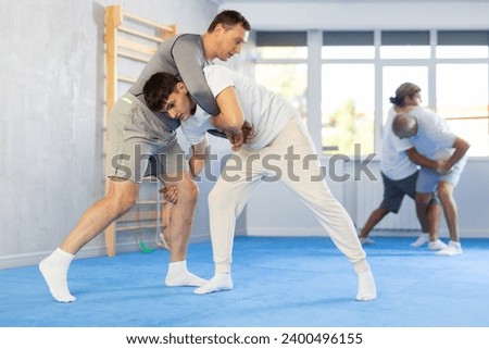 Guy and man during one-on-one training fight are engaged in martial arts section. Fostering strong spirit and sturdy body.