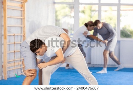 Guy and senior man athletes practice Brazilian jiu Jitsu Aikido Wing chun wrestling. Training at Academy of Martial Arts martial arts hand-to-hand combat.