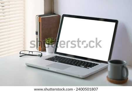 Mock up computer laptop with blank screen on wooden table at comfortable workplace.	