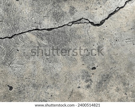 a photography of a crack in the concrete shows a crack in the ground. Royalty-Free Stock Photo #2400514821