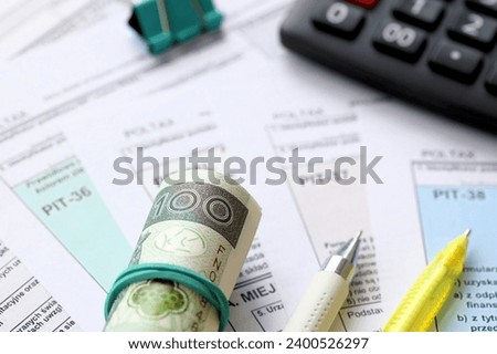 Declaration of the amount of earned income or incurred loss, PIT-36, PIT-36L, PIT-37 and PIT-38 tax forms on accountant table with pen and polish zloty money bills close up Royalty-Free Stock Photo #2400526297