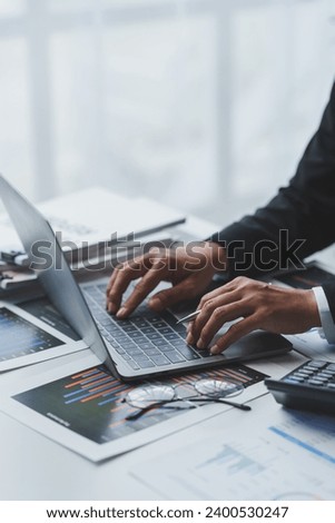 Asian business woman typing Search for information on your laptop Financial documents, graphs, charts for marketing analysis Tax administration Statistical report on the table in the office.