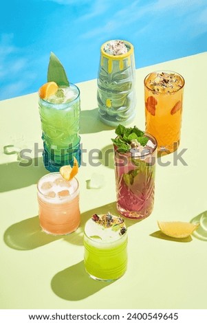 Summer cocktail ensemble with bold shadows and sunlight, perfect for a seasonal menu. Royalty-Free Stock Photo #2400549645