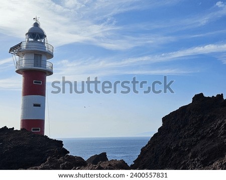 a lighthouse stands on the rocky coast of Tenerife