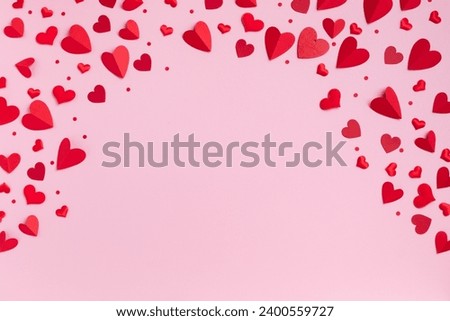 Valentine day festive greeting card with border of red hearts on pastel pink background top view. Flat lay style.