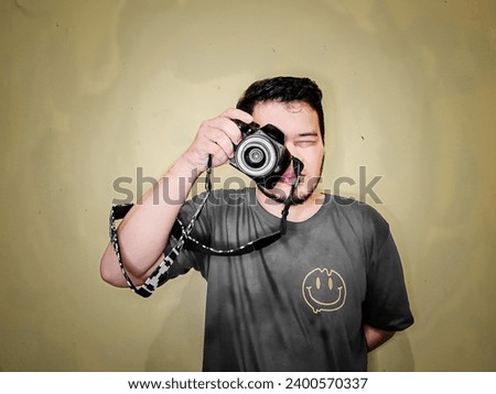 Photographer with his camera,  yellow background