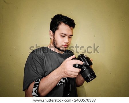 Photographer with his camera,  yellow background