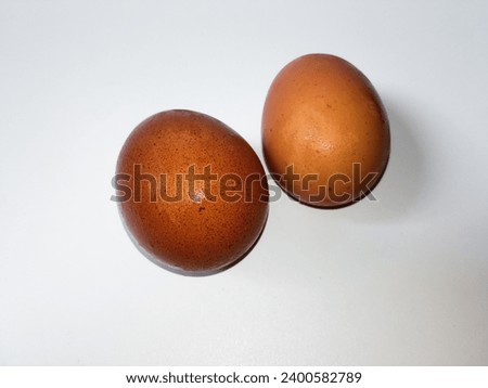  closeup of fresh raw two chicken eggs just taken from the refrigerator isolated on white background