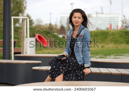 Beautiful young woman wearing jeans jacket enjoying outdoors. Portrait of beautiful young happy woman
