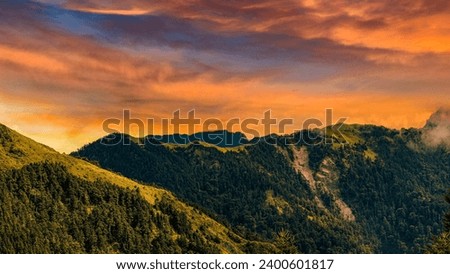 Rolling mountain,glow golden sky and winding valley grass view form a vast scenic scene. High quality photo photography in Hehuanshan,Nantou,Taiwan.Use in branding, screensavers, websites, etc.