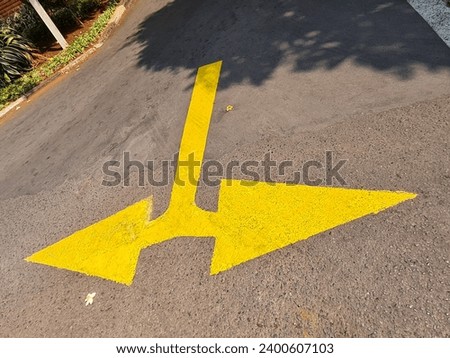 Right and left direction arrows painted in yellow on the road surface