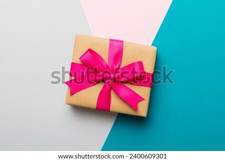 holiday paper present tied pink ribbon bow top view with copy space. Flat lay holiday background. Birthday or christmas present. Christmas gift box concept with copy space.