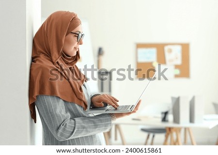 Young Muslim businesswoman working with laptop in office
