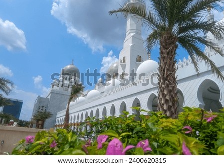The large building of the Syech Zayed Solo Mosque looks clear against the sky and trees in the mosque yard  Royalty-Free Stock Photo #2400620315