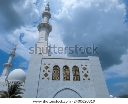 The large building of the Syech Zayed Solo Mosque looks clear against the sky and trees in the mosque yard  Royalty-Free Stock Photo #2400620319