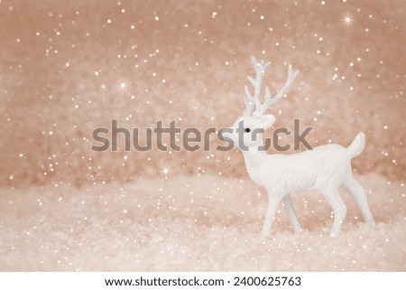 Christmas deer on a snowy background. New year card. Xmas concept with copy space. Demonstrating color of 2024 year - peach.