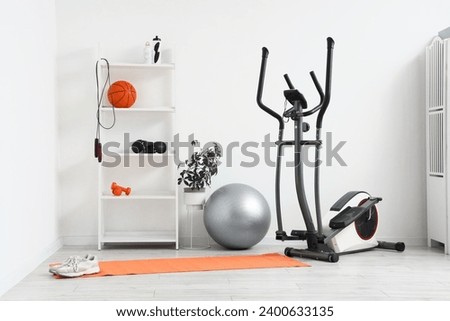 Interior of gym with shelf unit and sports equipment