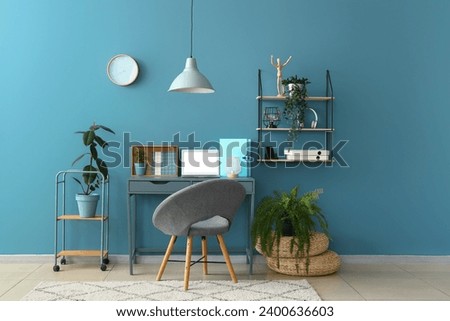 Stylish interior of room with comfortable workplace and houseplants Royalty-Free Stock Photo #2400636603