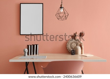 Stylish interior of room with workplace and blank poster hanging on color wall