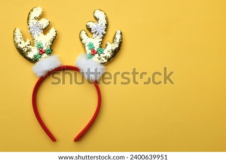 cute Headband Christmas, Christmas deer horns isolate on a yellow backdrop. concept of joyful Christmas party,New year is coming soon, festive season decoration with Christmas elements