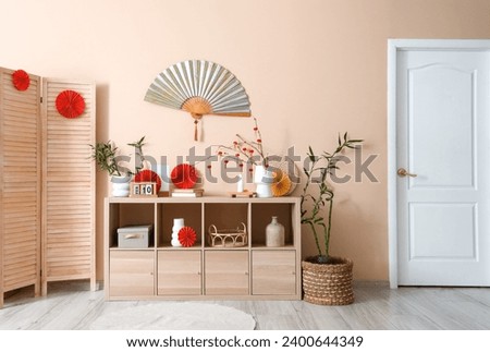 Wooden cabinet with decorations for Chinese New Year celebration in living room Royalty-Free Stock Photo #2400644349