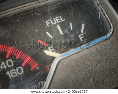 out of focus and blurry picture of the black meter panel of a motorcycle. there are writings, numbers, symbols and white meter needles. there are also symbols and lights of various colors