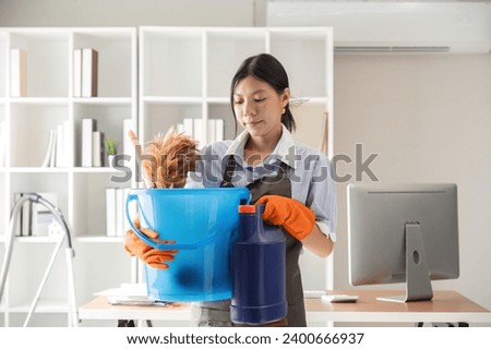 Young woman cleaning to disinfect computer and equipment on office table Cleaning staff or maid cleaning the office