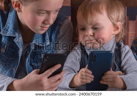 Internet or social media addiction. Funny facial expression of young girls with phone. Royalty-Free Stock Photo #2400670159