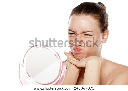 young woman making faces on the mirror 