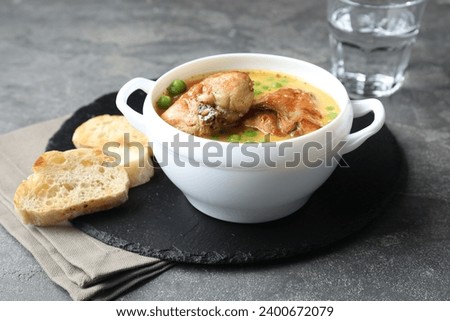 Tasty cooked rabbit meat with sauce served on grey table, closeup