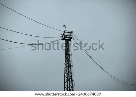 Tower with wires. Tower on the background of the sky. High Steel Tower. Steel Structure for Communication.