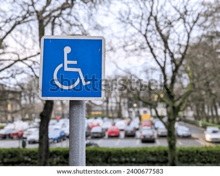 Blue disabled road sign on parking area for disabled people