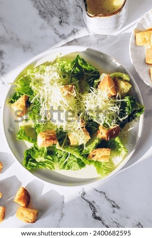 Classic caesar salad with lettuce, croutons and parmesan cheese. Caesar salad. Vegetarian tasty food recipe for cookbook. Diet fitness menu. Top view. High quality photo. Royalty-Free Stock Photo #2400682595