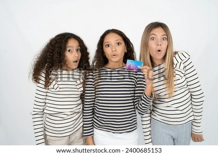 Photo of multi racial group of girl friends amazed shocked hold credit card payment