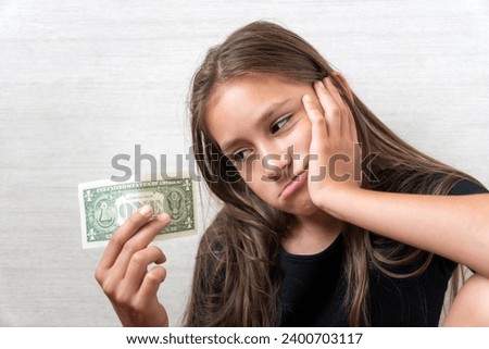 Sad child with money dollar. Not enough money. white background Royalty-Free Stock Photo #2400703117