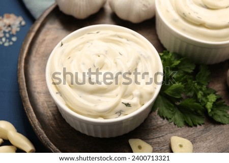 Tasty sauce with garlic and parsley on blue wooden table, closeup