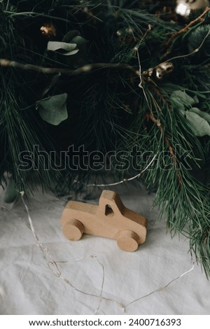 wooden New Year's toy car on a background of green spruce and pine branches close-up