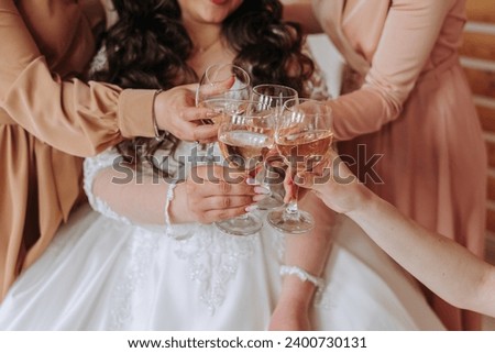Friends rejoice with the bride in the morning. They take pictures, smile, help the bride fasten her dress.
