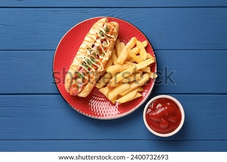 Delicious hot dog with bacon, carrot and parsley served on blue wooden table, flat lay Royalty-Free Stock Photo #2400732693