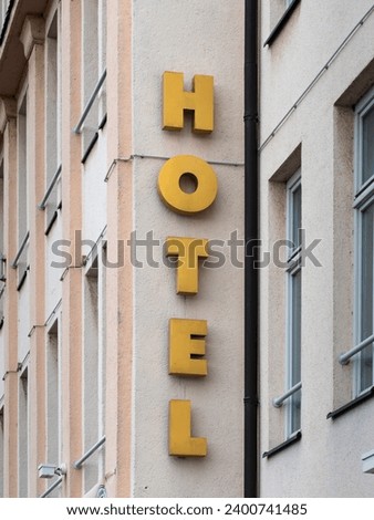 Hotel sign on a building exterior. The symbol advertises for an accommodation business in the hospitality industry. Tourists and business people need a place to rest.