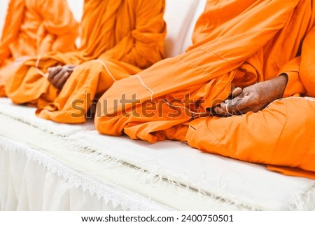 close up monk's hand holding holy thread, buddhist holy day, thai buddhist monk ordination ceremony wallpaper background concep