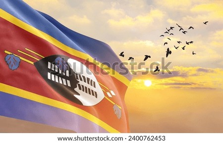Waving flag of Eswatini against the background of a sunset or sunrise. Eswatini flag for Independence Day. The symbol of the state on wavy fabric.