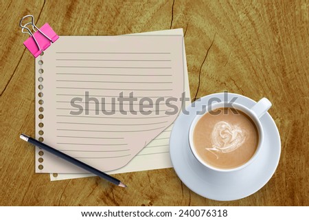 paper and coffee cup on wooden background.