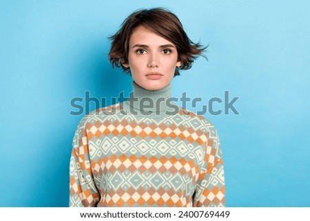 Photo of focused serious young girl calm face wear green sweater isolated on blue color background