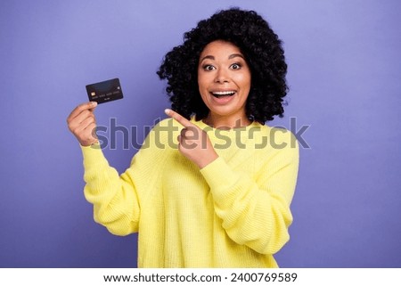 Photo portrait of lovely young lady hold credit card excited cheerful dressed stylish yellow garment isolated on violet color background