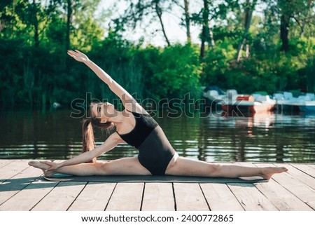 Beautiful Asian woman sitting twine, enjoying peaceful morning yoga session by tranquil river, finding harmony and tranquility in the beauty of the natural surroundings.